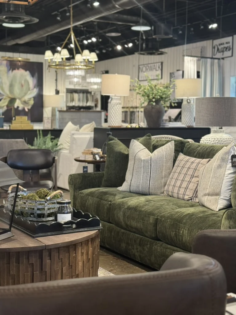 Green sofa, layered cushions, lamps, and furniture inside the JD's showroom