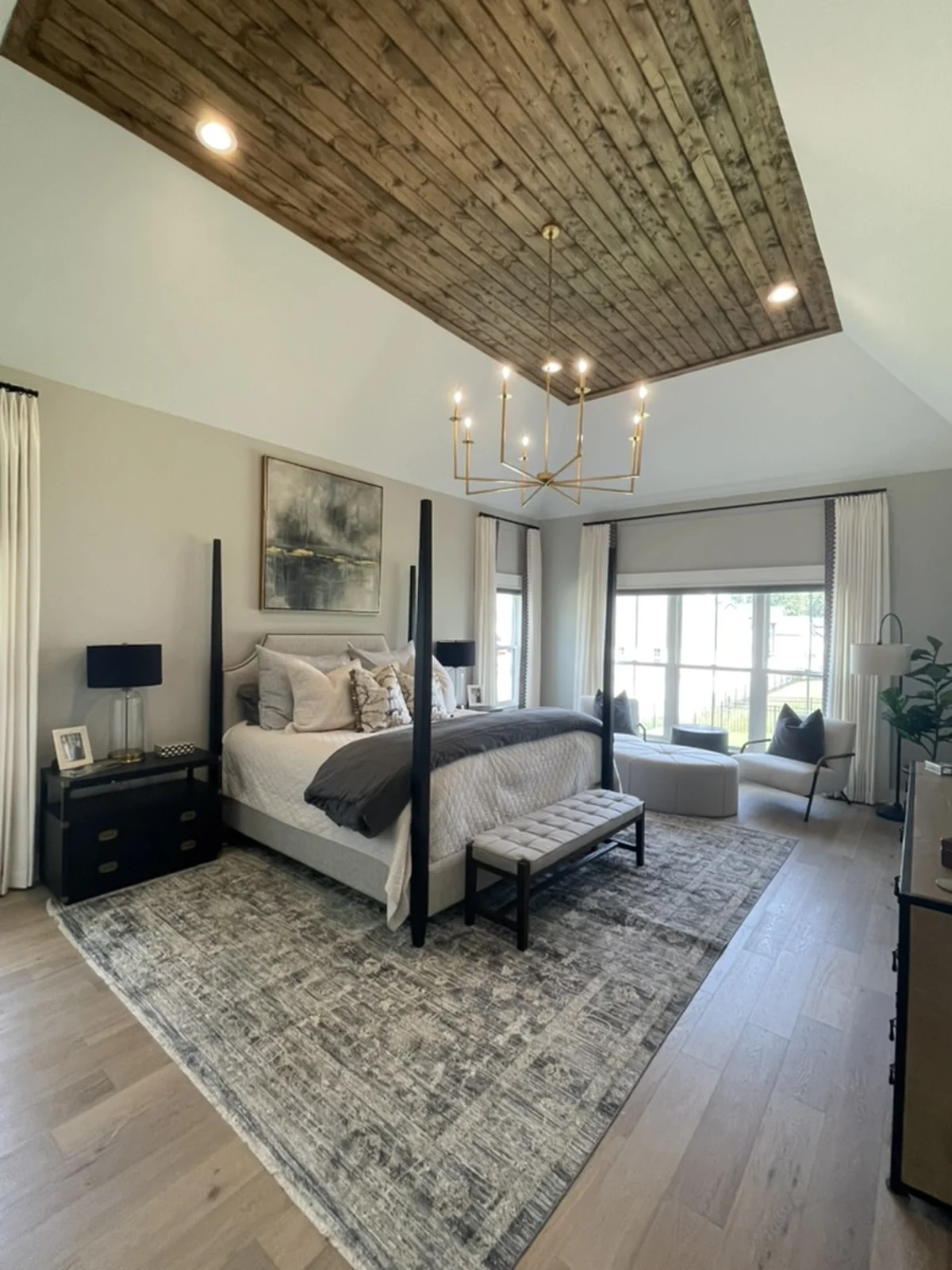 Completed bedroom with a four-poster bed, exposed beams, and layered furnishings