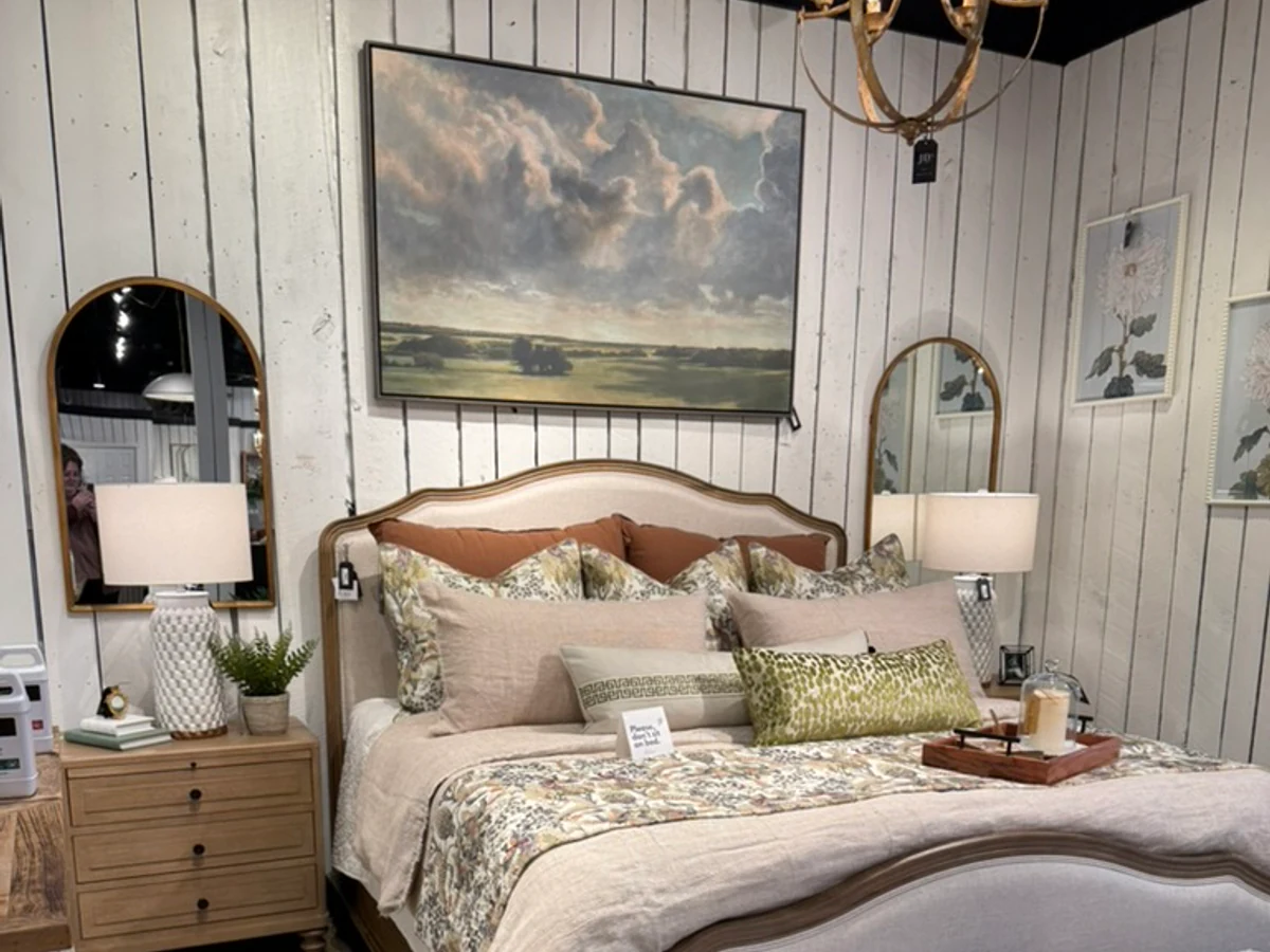 Upholstered bed, lighting, art, and bedding displayed in the JD's showroom