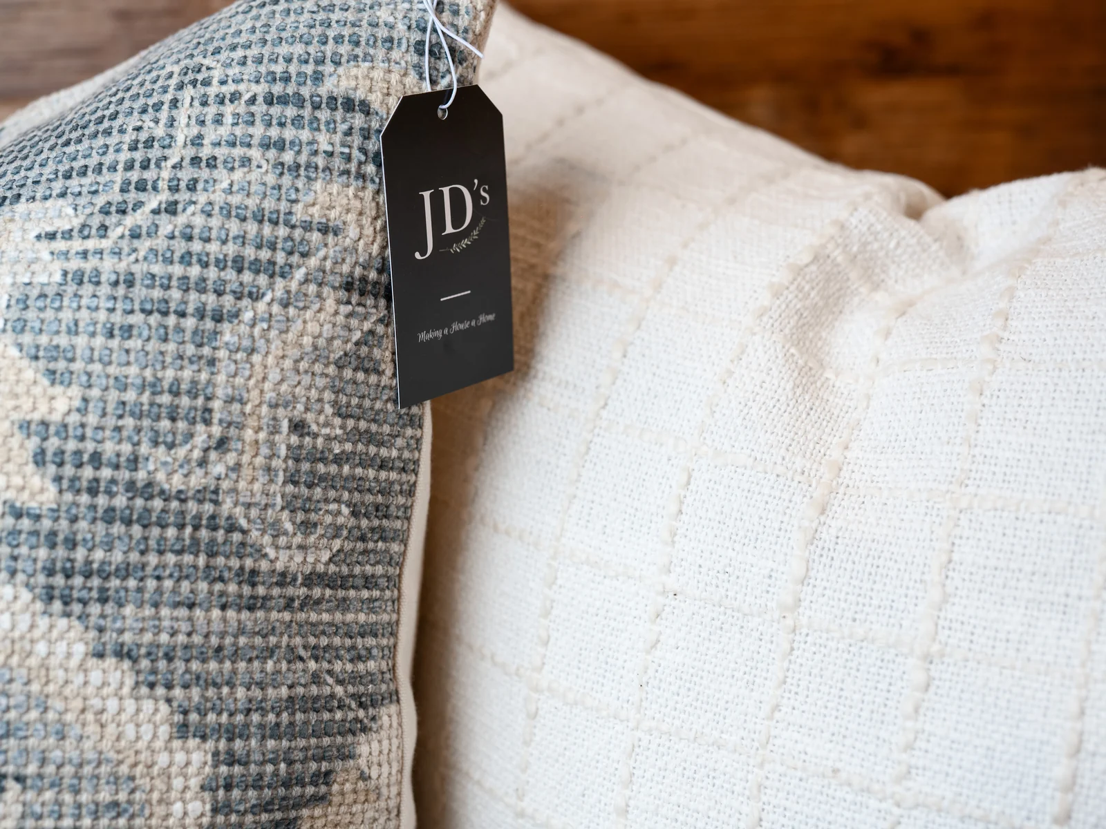 Blue-and-white upholstery fabrics and pillows displayed with JD's tags
