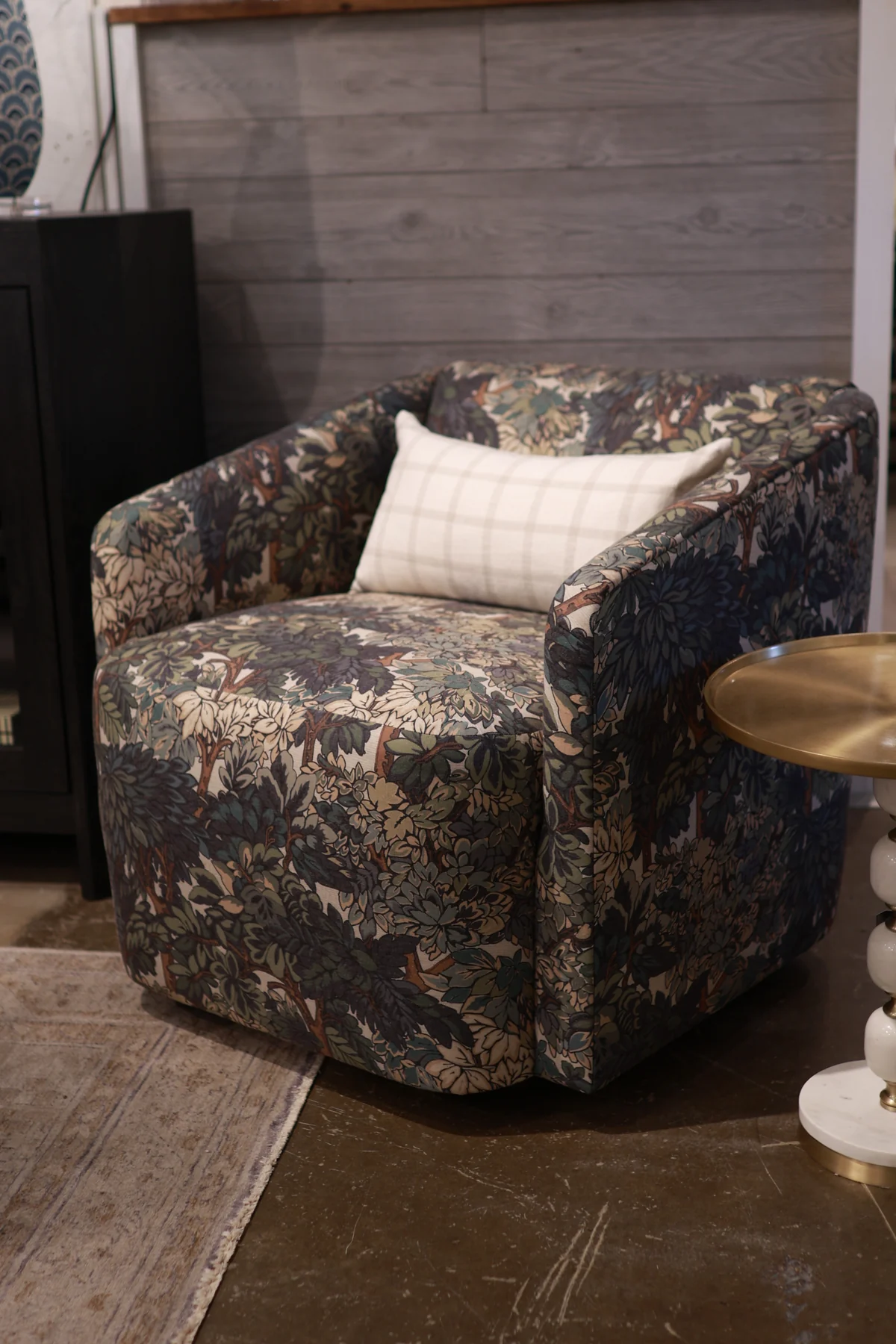 Norwalk accent chair in a dark botanical upholstery fabric with a light plaid pillow