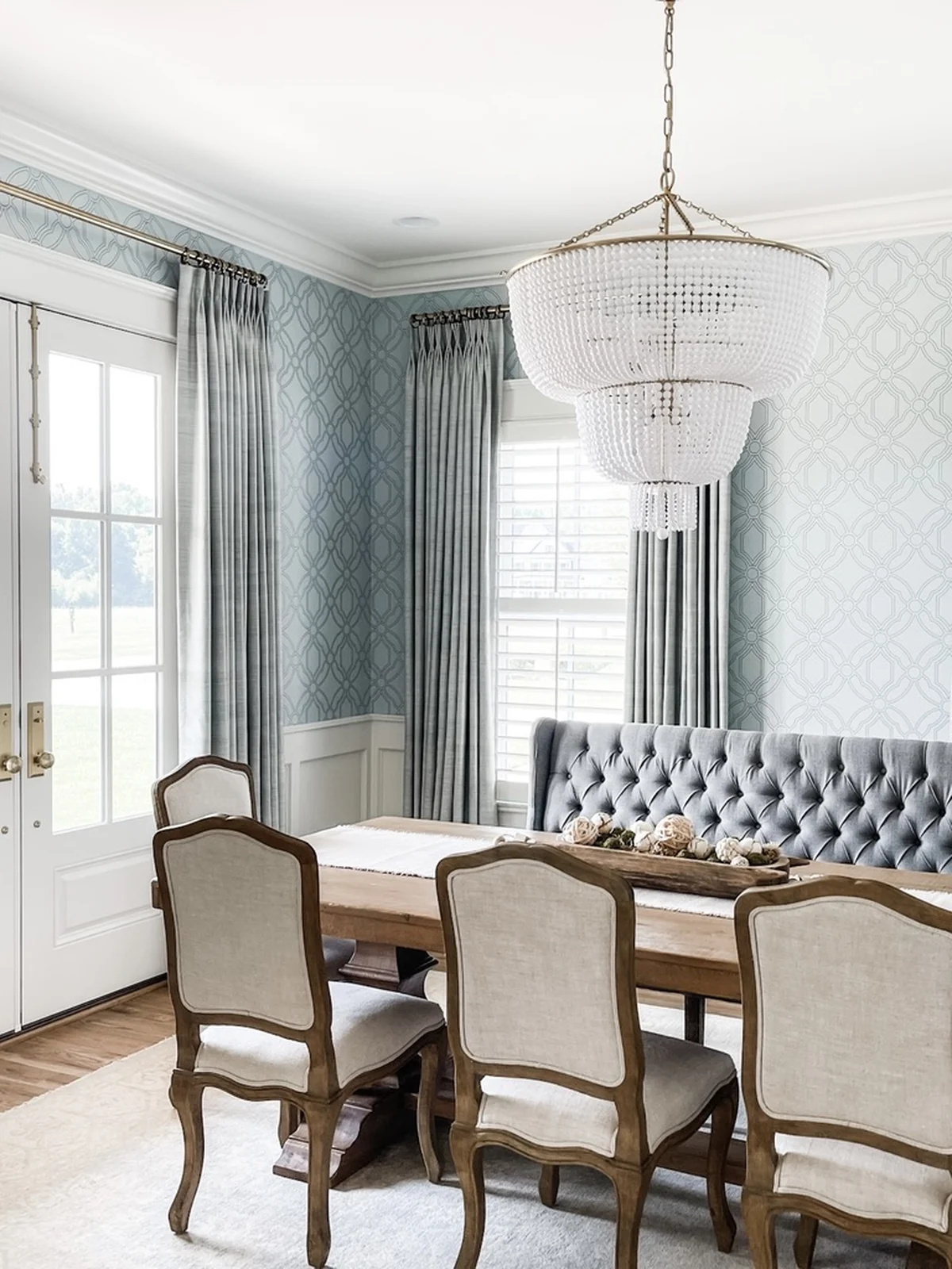 Dining room with floor-length window panels and a tufted banquette